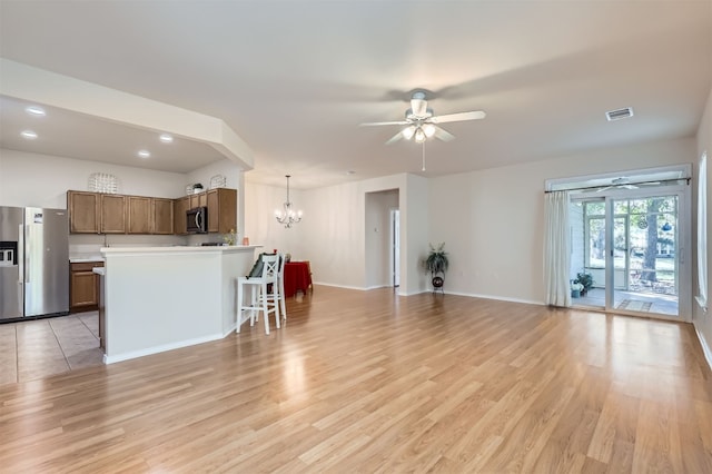 kitchen with pendant lighting, a center island, stainless steel appliances, and light hardwood / wood-style floors