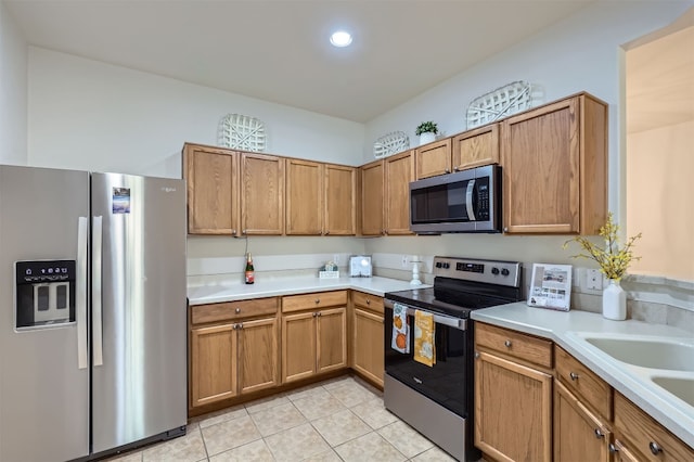 kitchen with light tile patterned floors, sink, and appliances with stainless steel finishes