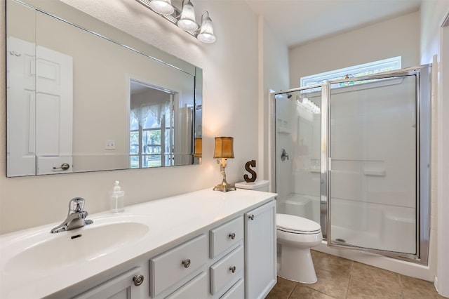 bathroom with a shower with door, tile patterned flooring, a healthy amount of sunlight, and toilet