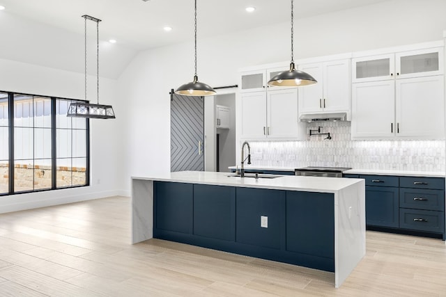 kitchen featuring white cabinets, backsplash, decorative light fixtures, and sink