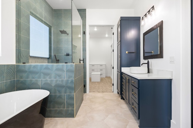 bathroom featuring independent shower and bath, vanity, tile walls, and tile patterned flooring