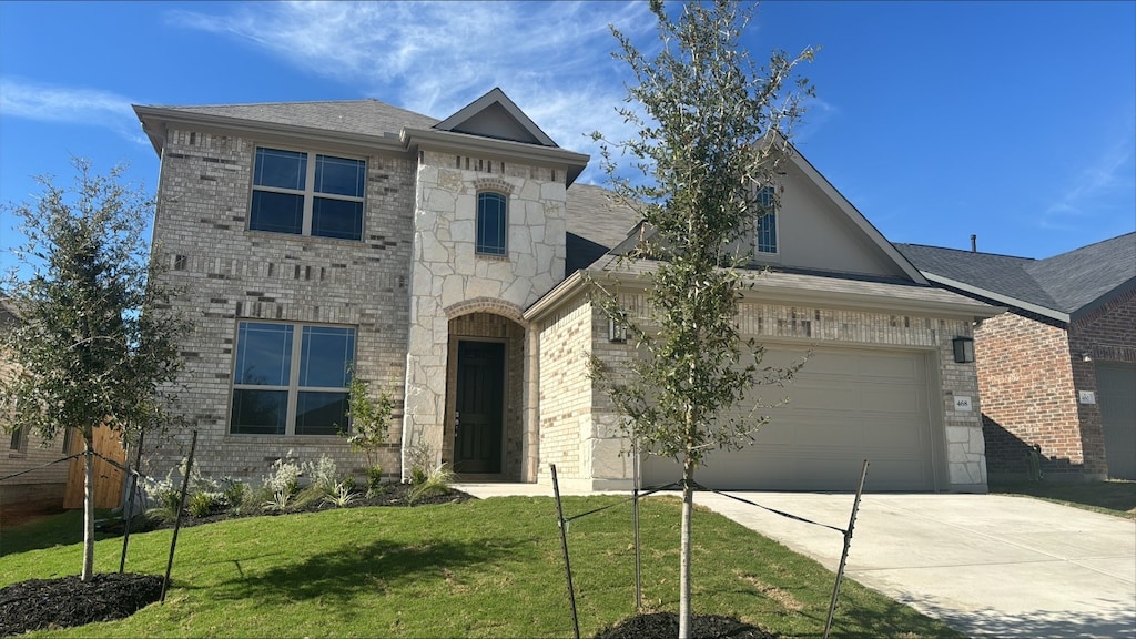 view of front of property featuring a front lawn and a garage