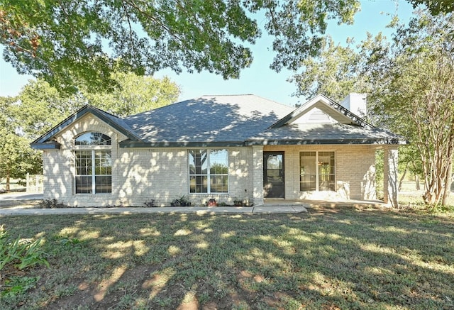 view of front of house with a patio and a front yard