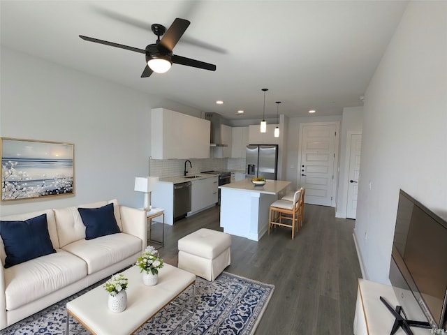 living room featuring ceiling fan, dark hardwood / wood-style floors, and sink