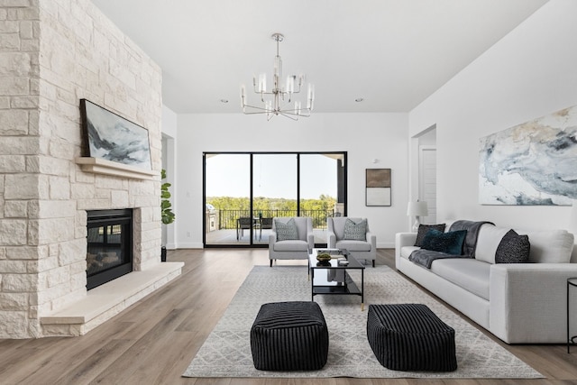 living room with a fireplace, wood-type flooring, and a notable chandelier