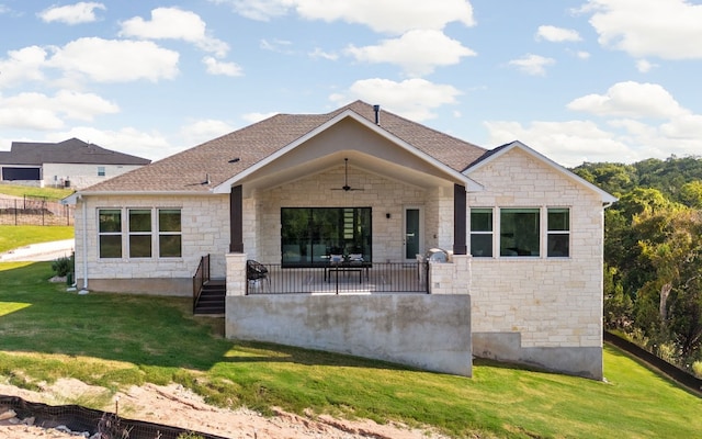 back of property with a yard and ceiling fan