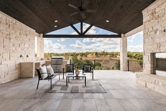 view of patio with area for grilling, sink, an outdoor stone fireplace, grilling area, and ceiling fan