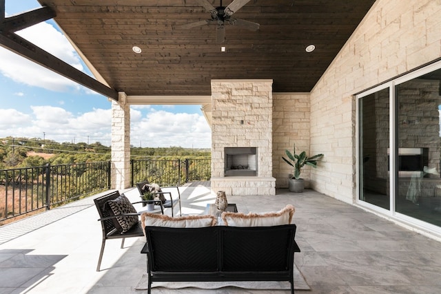 view of patio featuring ceiling fan and an outdoor living space with a fireplace