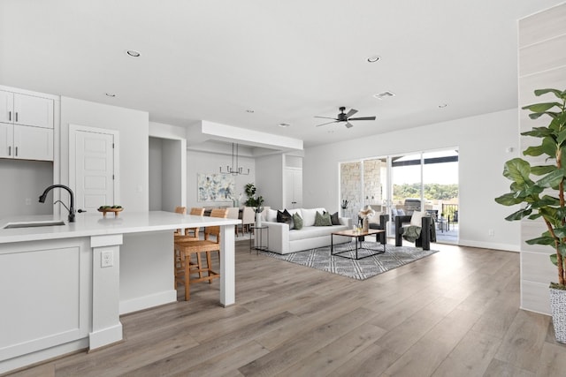 living room with a ceiling fan, recessed lighting, visible vents, and light wood-type flooring