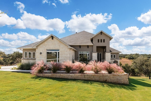 view of front of property featuring stucco siding, stone siding, and a front lawn