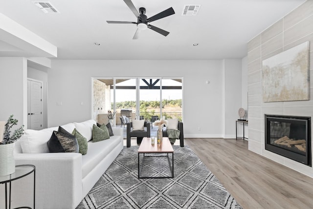 living room featuring hardwood / wood-style floors, a fireplace, and ceiling fan