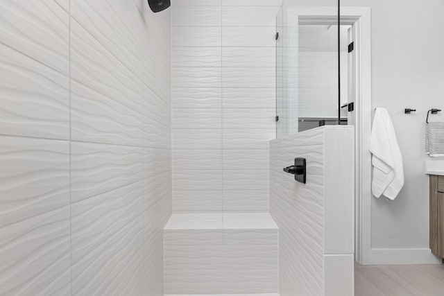 bathroom with vanity and a tile shower