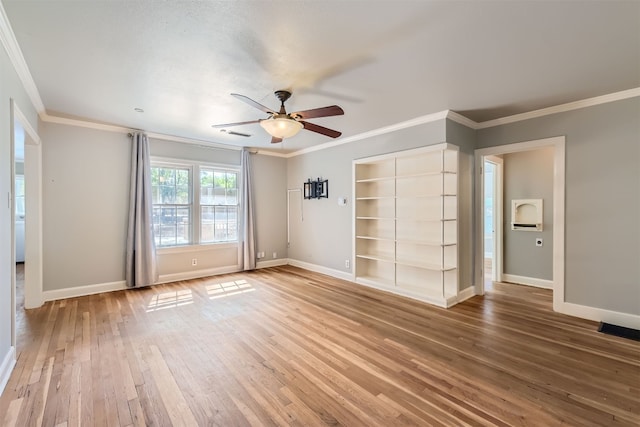 unfurnished room with built in shelves, ceiling fan, hardwood / wood-style floors, and crown molding