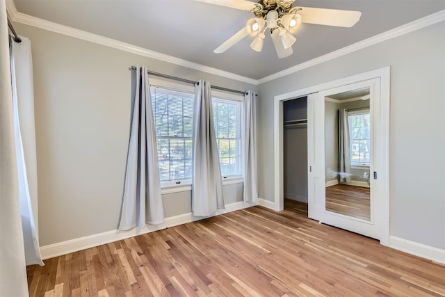 unfurnished bedroom featuring a closet, light hardwood / wood-style floors, ceiling fan, and crown molding