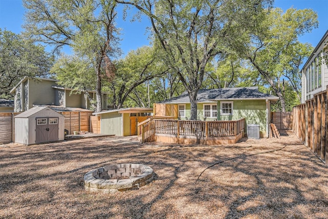 back of house featuring a storage unit, a wooden deck, central AC, and an outdoor fire pit