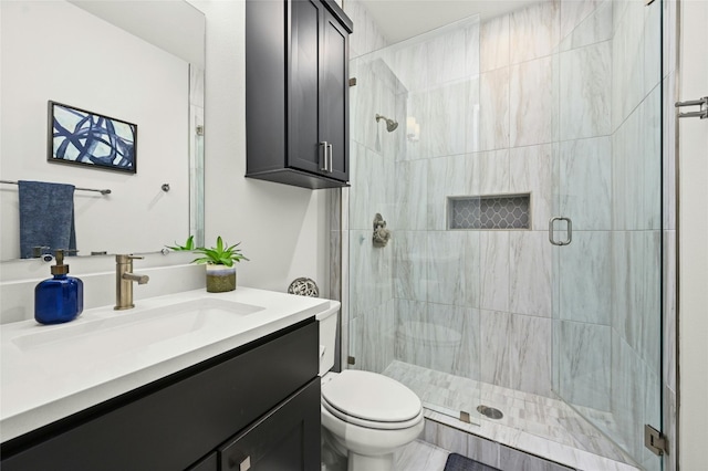 bathroom featuring vanity, toilet, and an enclosed shower