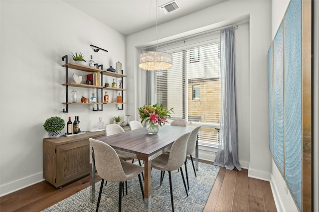 dining area with a notable chandelier, dark hardwood / wood-style floors, and plenty of natural light