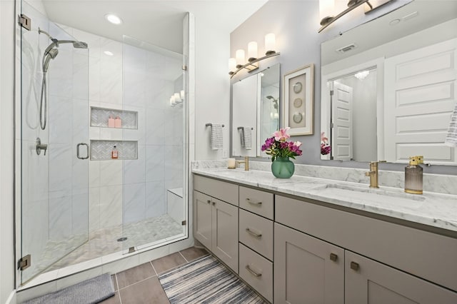 bathroom with vanity, an enclosed shower, and tile patterned floors