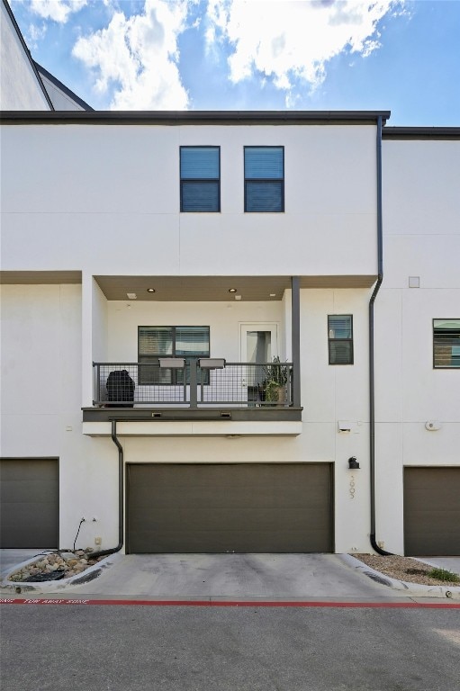 view of property with a balcony and a garage