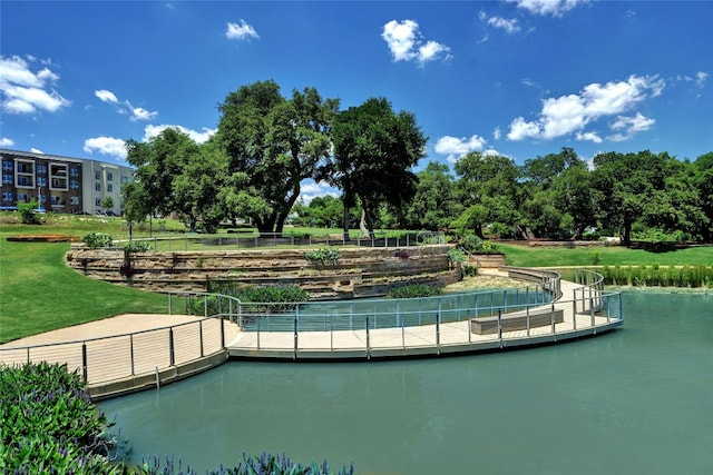 view of property's community with a water view and a yard