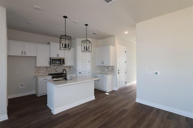 kitchen with white cabinetry, an island with sink, appliances with stainless steel finishes, and pendant lighting