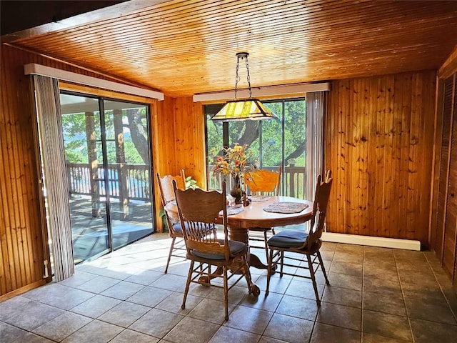 18111 Gregg Bluff Rd, Jonestown, TX 78645 - dining area with wood ceiling, wooden walls, plenty of natural light, and dark tile patterned flooring