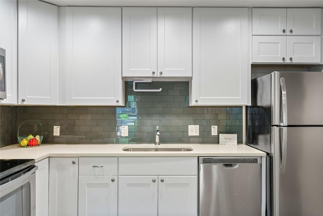 kitchen with light countertops, white cabinets, appliances with stainless steel finishes, and a sink