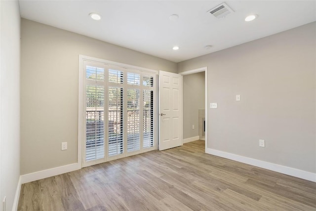 spare room with visible vents, light wood-type flooring, and baseboards