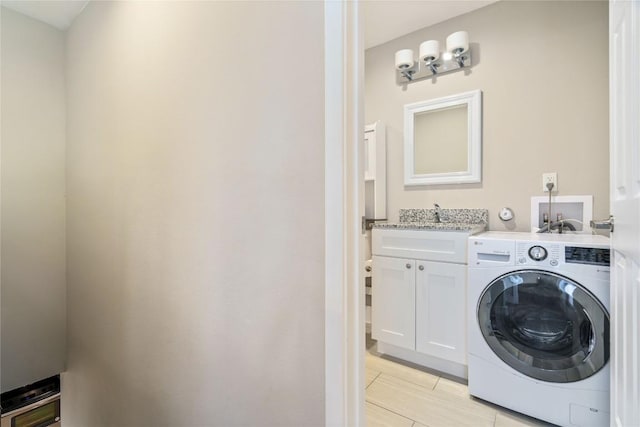 clothes washing area featuring cabinet space and washer / dryer