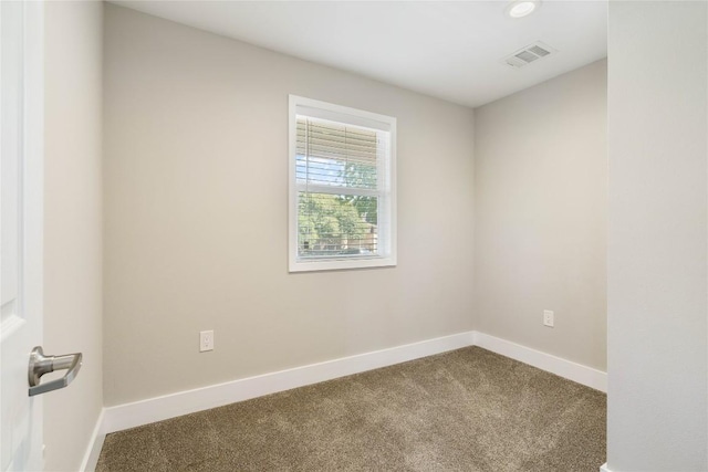 unfurnished room featuring visible vents, carpet floors, and baseboards