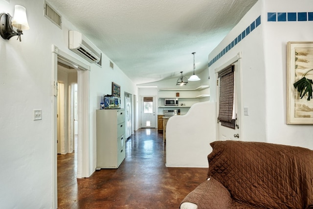 hallway featuring a textured ceiling, vaulted ceiling, and an AC wall unit