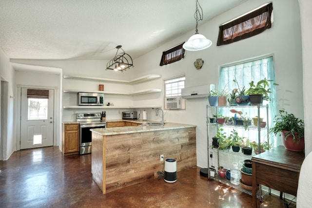 kitchen featuring pendant lighting, kitchen peninsula, a textured ceiling, stainless steel appliances, and vaulted ceiling