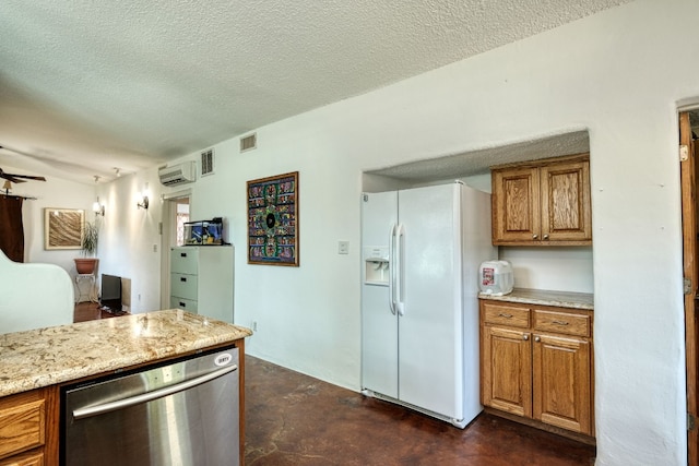 kitchen with light stone counters, a textured ceiling, white refrigerator with ice dispenser, a wall mounted AC, and stainless steel dishwasher