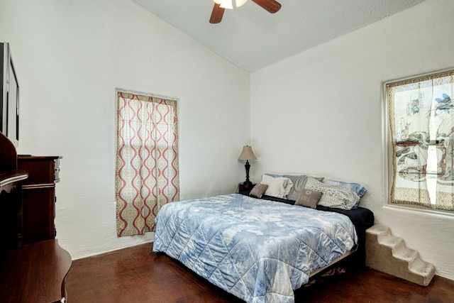 bedroom featuring lofted ceiling, dark carpet, and ceiling fan