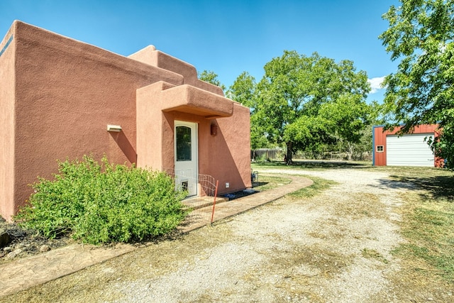 view of side of property featuring a garage and an outbuilding