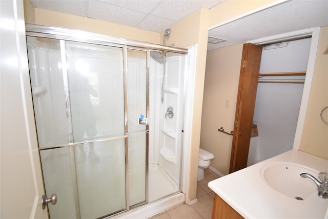 bathroom featuring walk in shower, vanity, toilet, and tile patterned floors