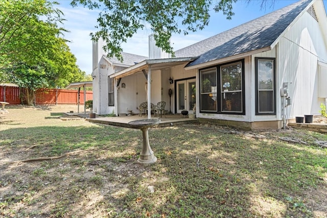 rear view of house featuring a lawn and a patio