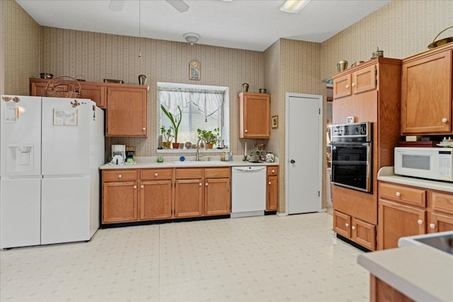 kitchen featuring white appliances, ceiling fan, decorative light fixtures, and sink