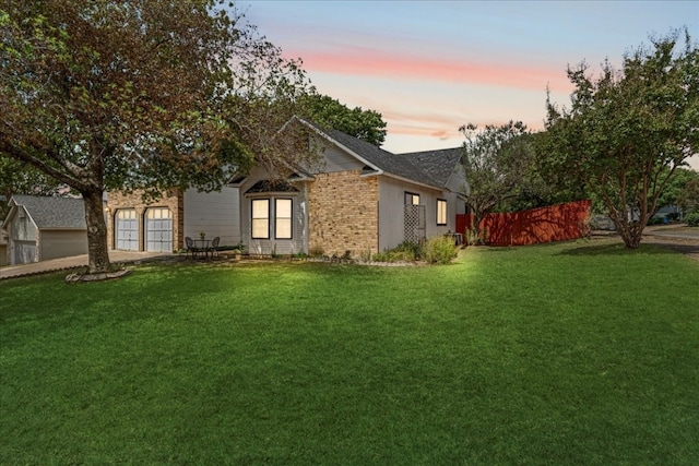 yard at dusk featuring a garage