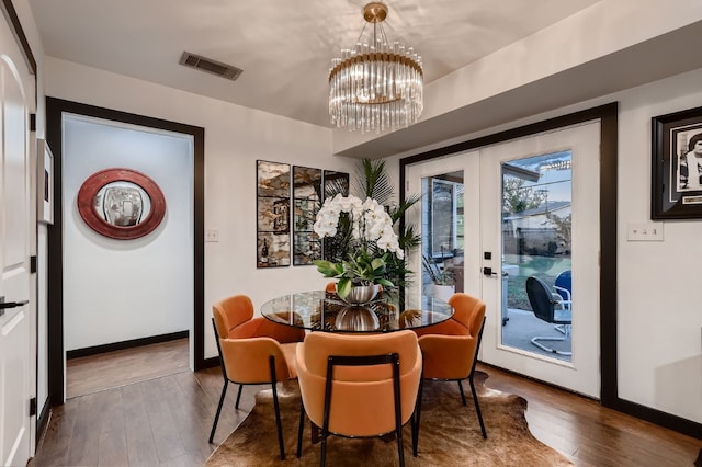 dining room featuring french doors, a chandelier, and hardwood / wood-style floors