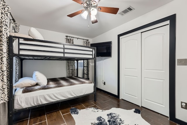 bedroom featuring dark hardwood / wood-style flooring, ceiling fan, and a closet