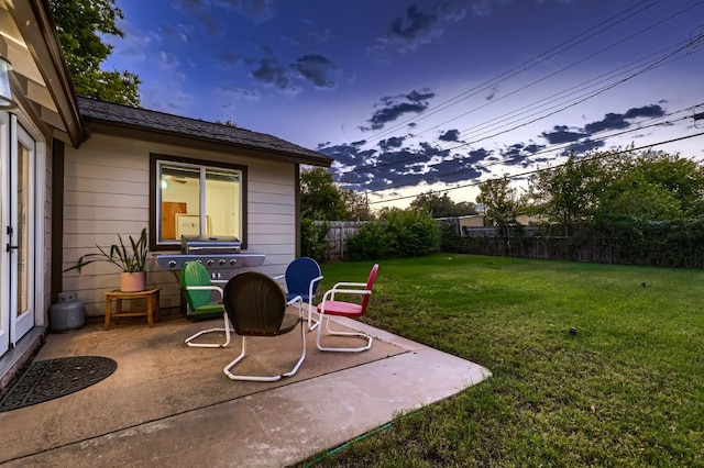 yard at dusk featuring a patio