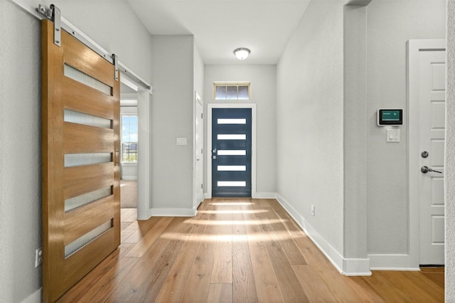 entrance foyer with a barn door and hardwood / wood-style flooring