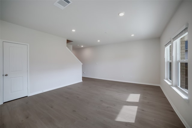 empty room with plenty of natural light and dark wood-type flooring