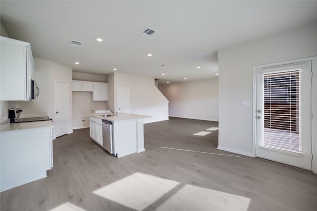 kitchen featuring light wood-type flooring, a center island with sink, white cabinetry, and stainless steel appliances