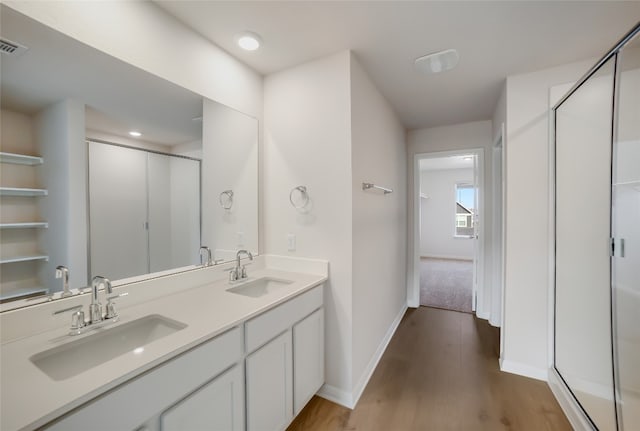 bathroom with hardwood / wood-style floors, vanity, and walk in shower