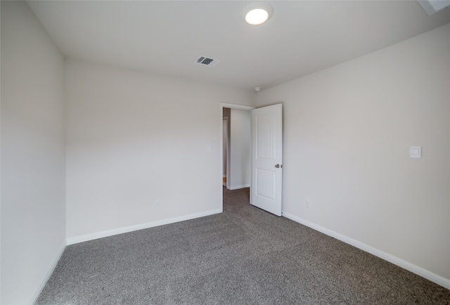 unfurnished room featuring dark carpet