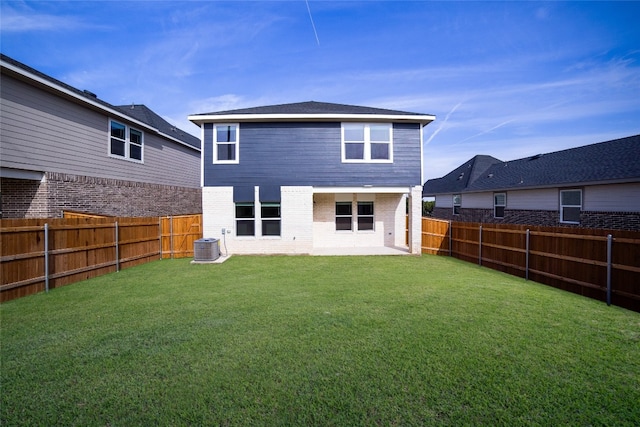 back of house featuring central AC and a yard