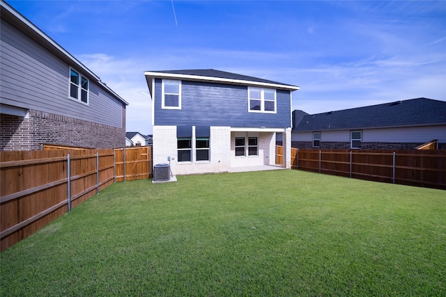 back of house with central AC and a yard