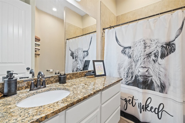 bathroom featuring walk in shower and vanity